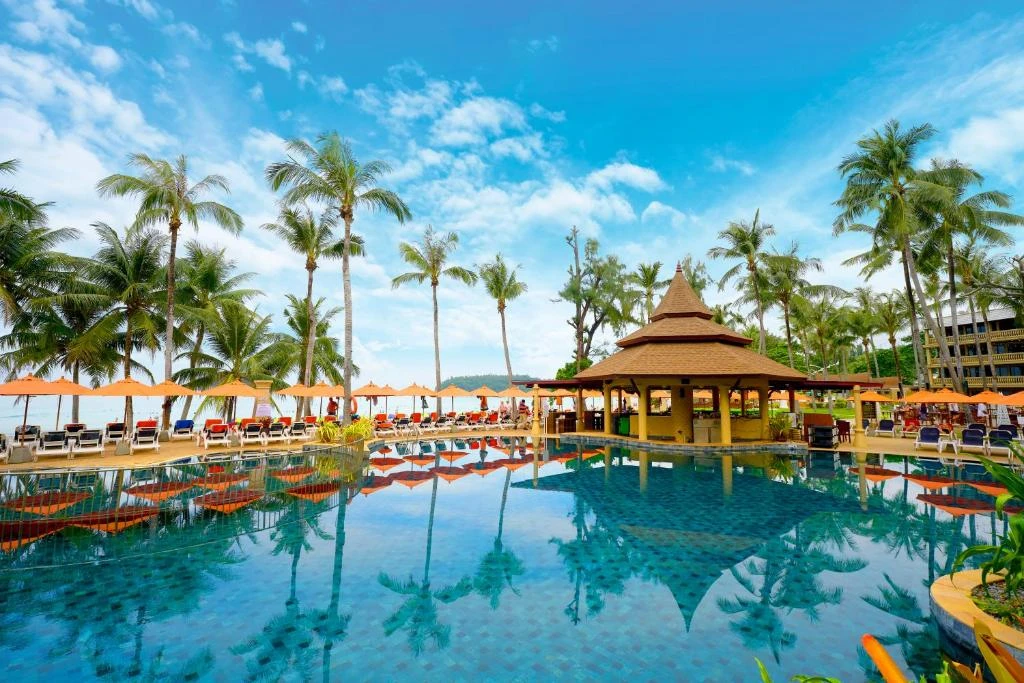 Pool, palms and sun lounges at Beyond Kata Beach Resort